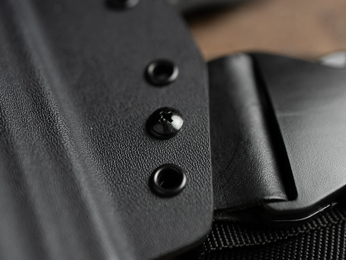 Coldre Hunter sobre mesa de madeira com revolver, detalhando o Kydex moldado